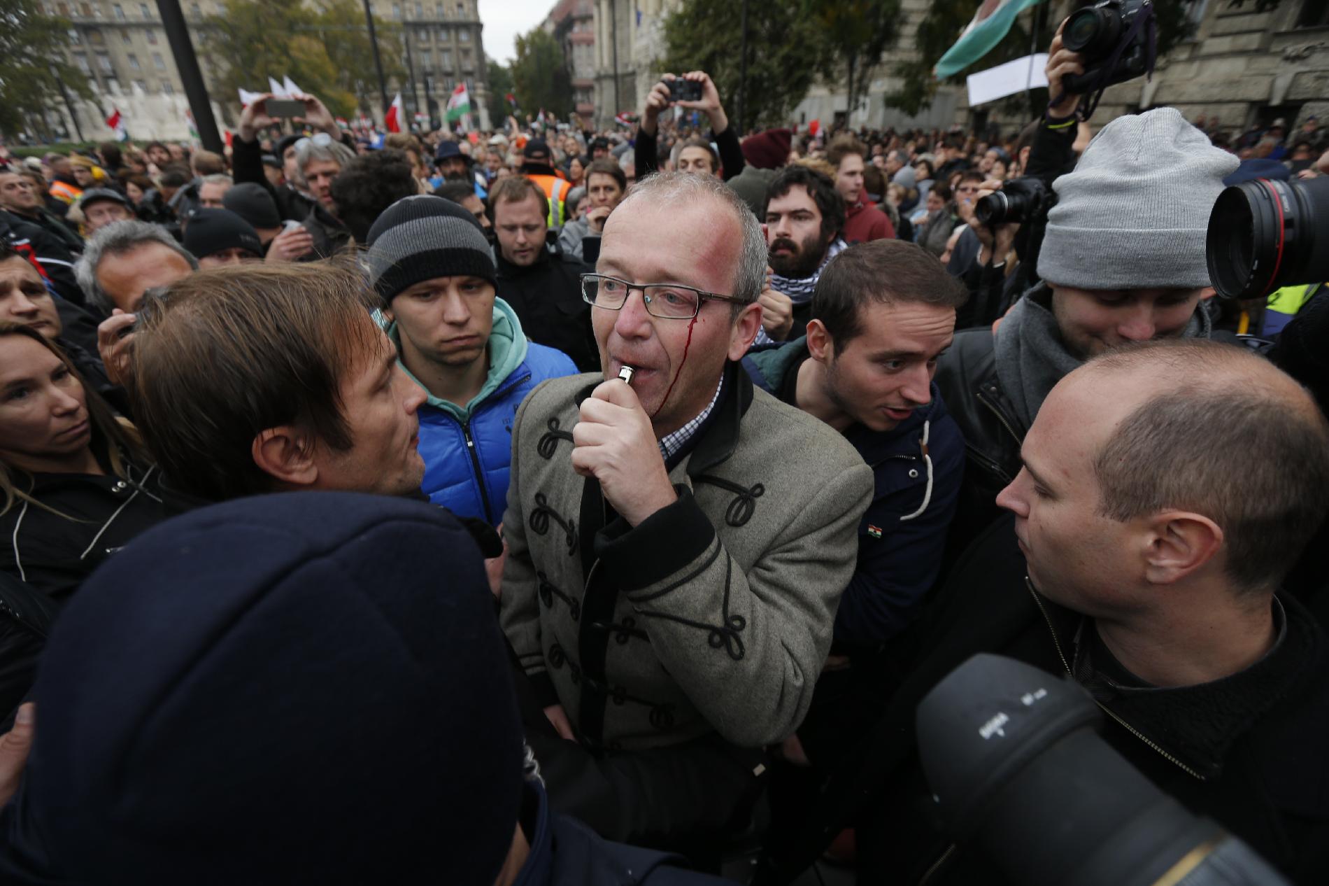 Ungváry Krisztián történész a tüntetők között, vérző fejjel fújja sípot