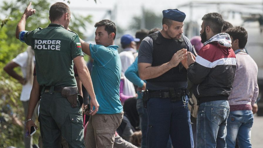 A Frontex bolgár munkatársa és egy magyar rendőr illegális bevándorlókat informál Röszke határában 2015. szeptember 9-én